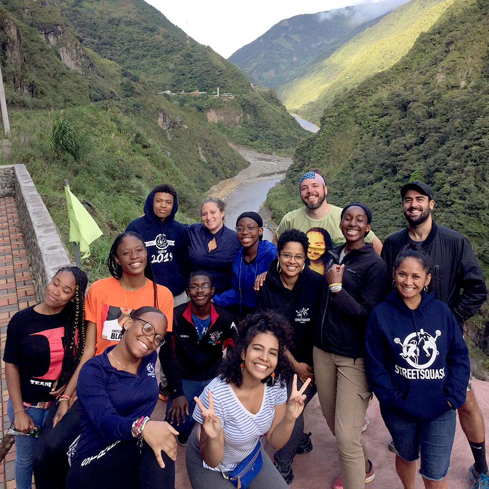 thirteen educational tourists taking a break in the crack of a mountain pass